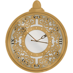 A gold watchface with intricate designs cut into it. The clock behind the gold casing is from Jan. 2023 and used in a merch design.
